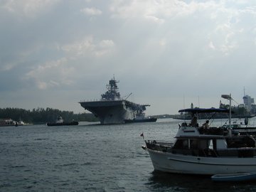 Tugs helping carrier leave port